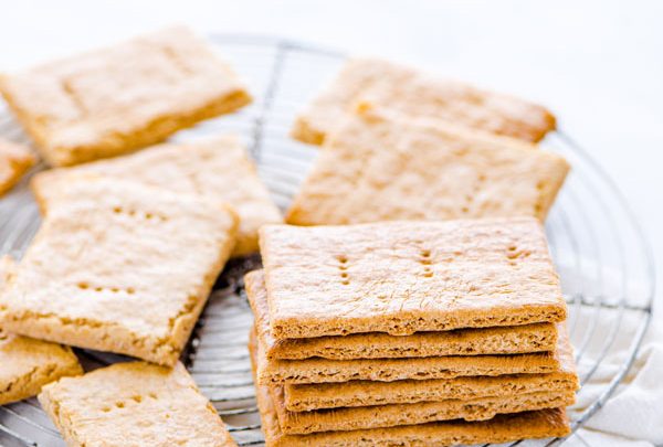 gluten free graham crackers stacked and piled on a round wire metal cooling rack