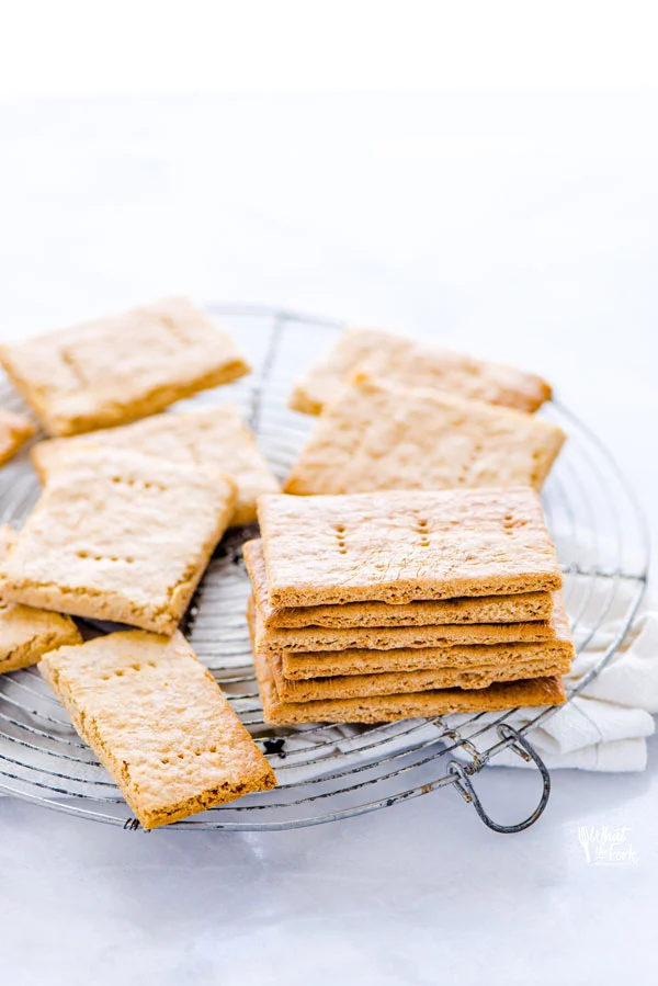 gluten free graham crackers stacked and piled on a round wire metal cooling rack