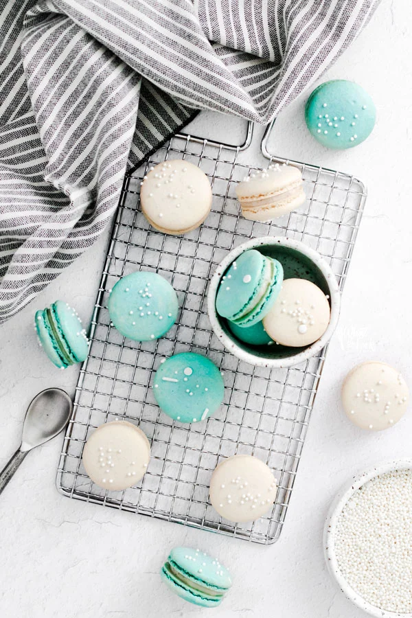 overhead shot of white and blue French Macarons on a small wire rack