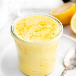 finished Lemon Curd recipe in a glass Weck Jar on a white plate, topped with lemon zest