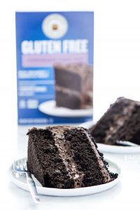 slices of Gluten Free Brooklyn Blackout Cake on white plates with a box of King Arthur Baking Company Gluten Free Chocolate Cake Mix in the background