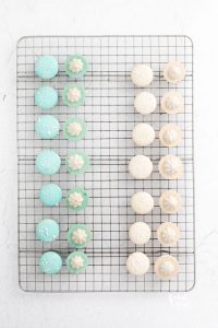 white and blue French Macarons on a wire rack filled and ready to be sandwiched