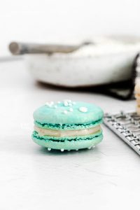 a blue French Macaron on a white surface