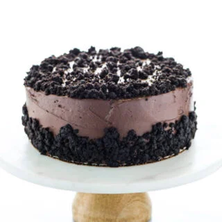 Gluten Free Brooklyn Blackout Cake on a white cake marble stand with a wood base