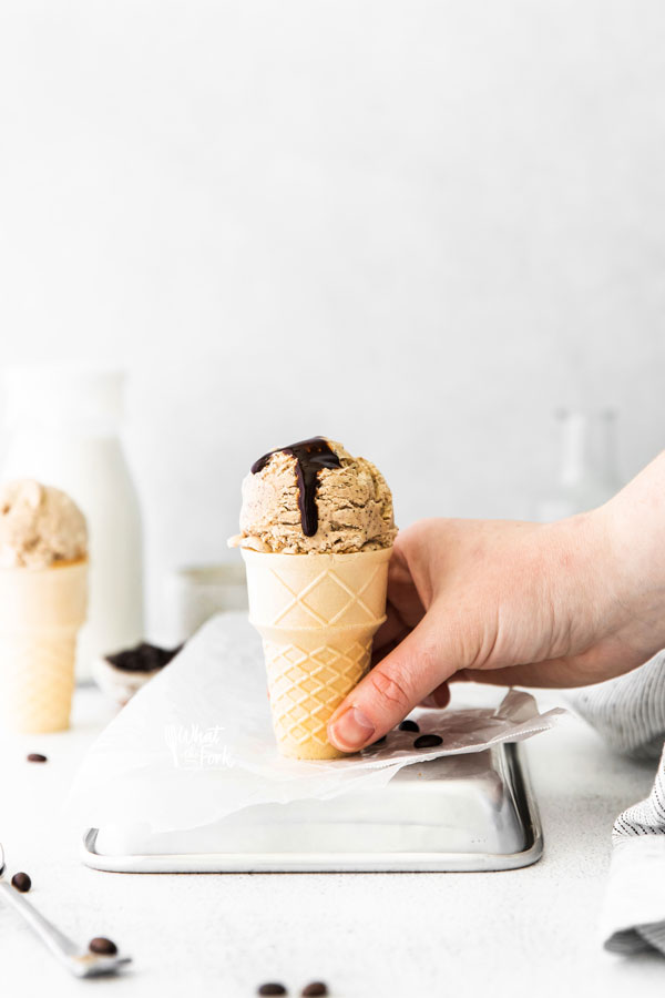 a hand picking up an ice cream cone filled with no churn coffee ice cream