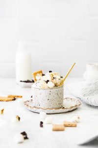 No Churn S'mores Ice Cream in a pottery cup on a pottery plate with a gold spoon