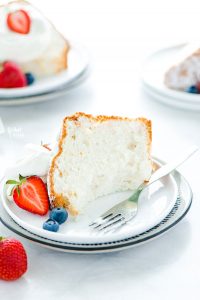 a slice of gluten free angel food cake on a plate with a bite taken out
