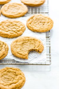 Gluten Free Brown Sugar Cookies on a wire rack, one with a bite taken out