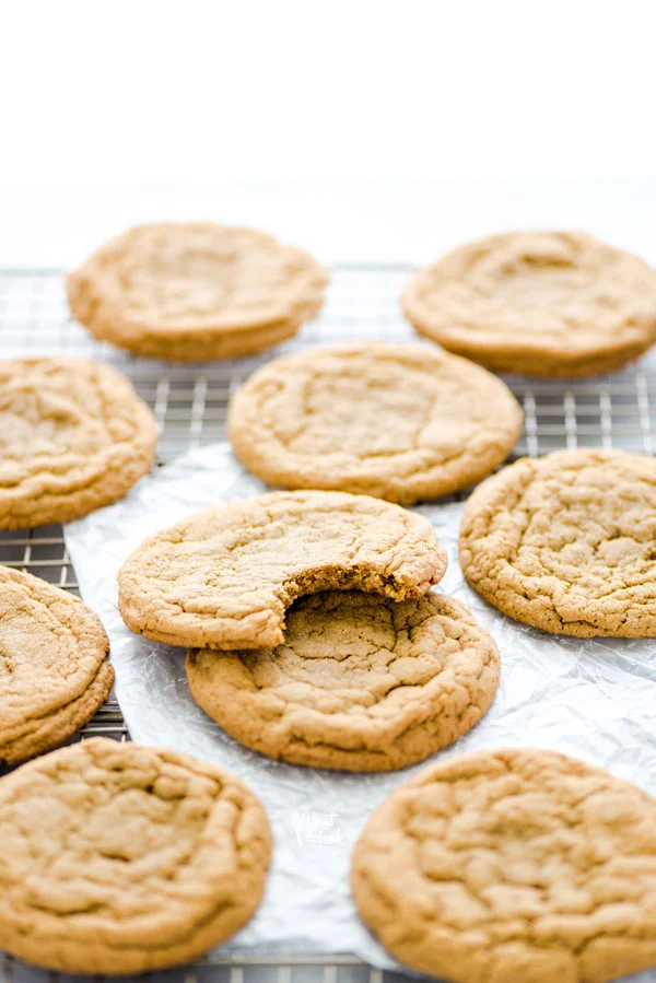 Gluten Free Brown Sugar Cookies on a wire rack, one with a bite taken out