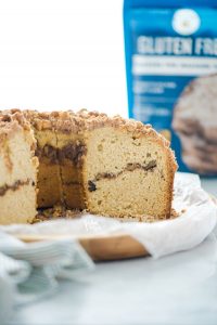 gluten free sour cream coffee cake sliced into with a bag of King Arthur Gluten Free Measure for Measure Flour in the background