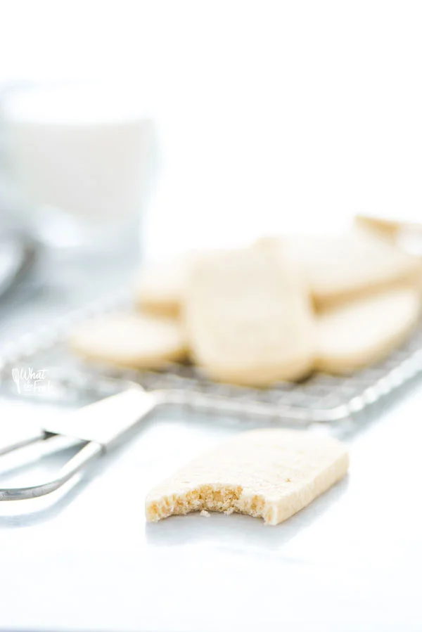 a shortbread cookie on a marble surface with a bite taken out