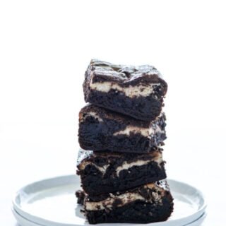 a stack of Gluten Free Cheesecake Brownies on a white plate