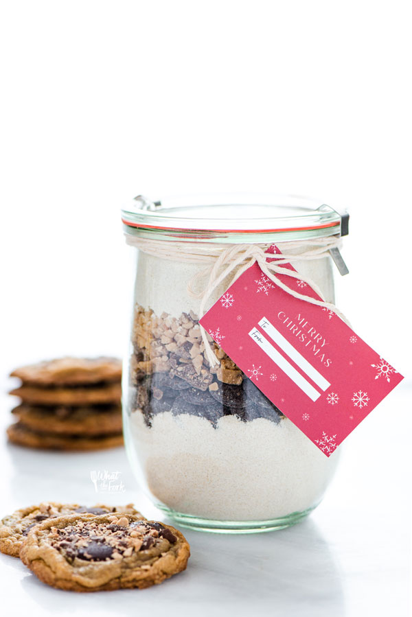 a gluten free Christmas Cookie jar with baked gluten free chocolate toffee cookies next to it