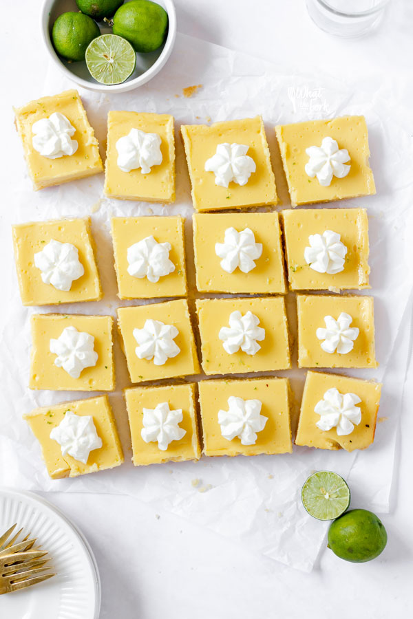 overhead shot of sliced gluten free key lime pie bars topped with a dollop of whipped cream