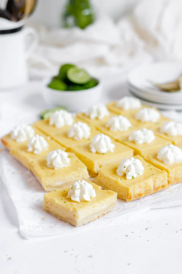 gluten free key lime pie bars sliced and topped with whipped cream ready to serve