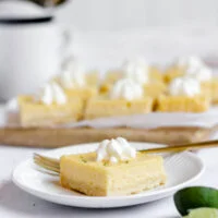 sliced gluten free key lime pie bars ready to serve with one piece on a small round white plate