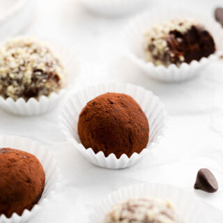 Amaretto Truffles in white paper liners rolled in cocoa powder and minced almonds