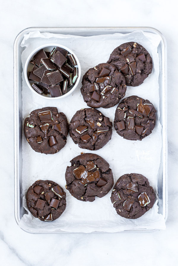 overhead shot of Gluten Free Andes Mint Chocolate Chip Cookies on parchment paper lined quarter sheet pan