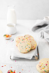 Gluten Free Shortbread Cookies with Sprinkles on a white parchment paper lined, upside-down quarter sheet pan