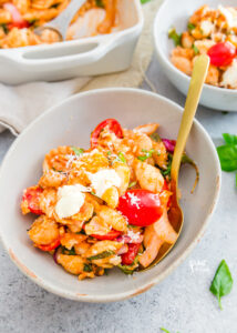 Caprese Pasta Bake Recipe with White Beans in a white bowl with a gold spoon