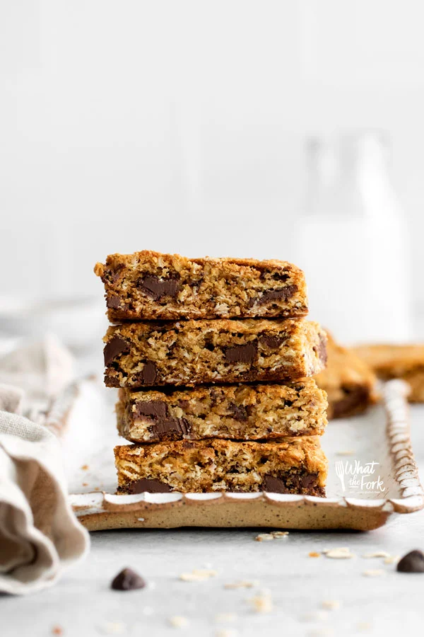 a stack of Gluten Free Oatmeal Chocolate Chip Bars on a small rectangular, wood tray