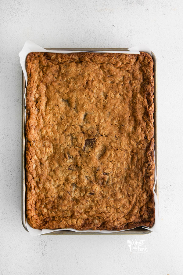 baked Gluten Free Oatmeal Chocolate Chip Bars on a quarter sheet pan lined with parchment paper