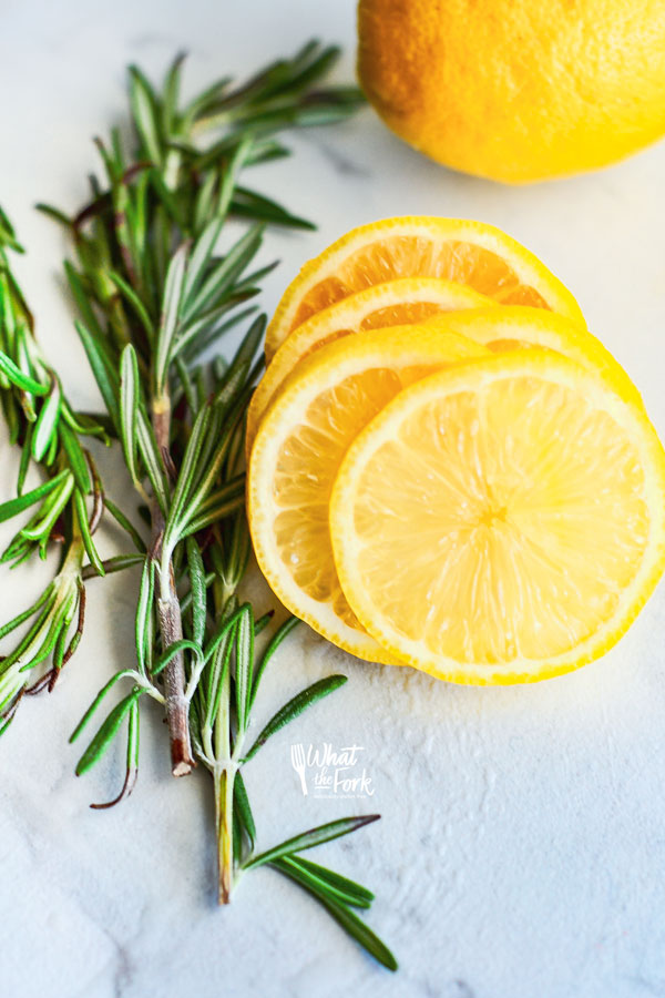 slices of lemon next to a few sprigs of fresh rosemary