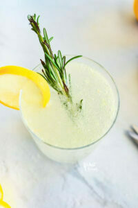 Non-Alcoholic Rosemary Citrus Spritzer in a clear glass garnished with a wheel of lemon and sprig of fresh rosemary