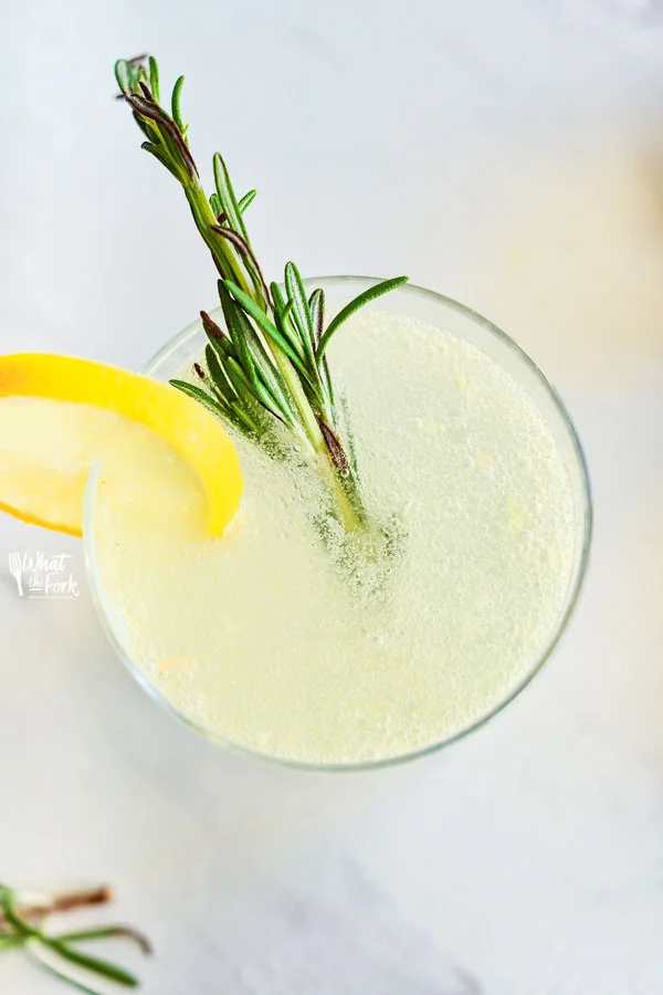 overhead shot of a Non-Alcoholic Rosemary Citrus Spritzer in a clear glass garnished with a wheel of lemon and a sprig of fresh rosemary