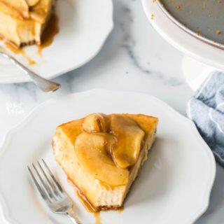 2 pieces of gluten free caramel apple cheesecake on white plates with silver forks