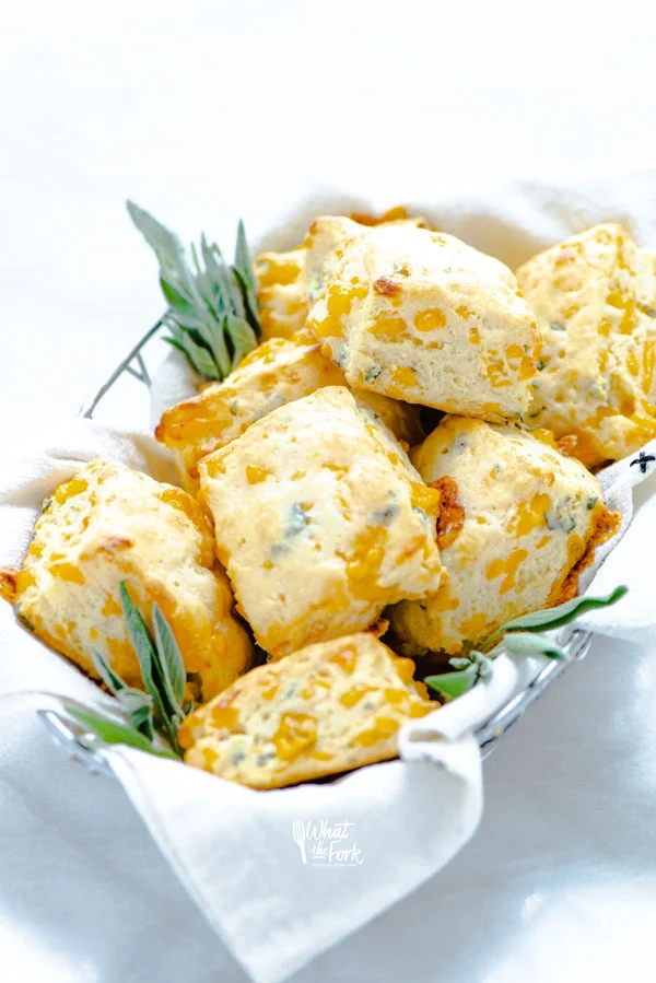 a basket filled with gluten free cheddar sage biscuits 