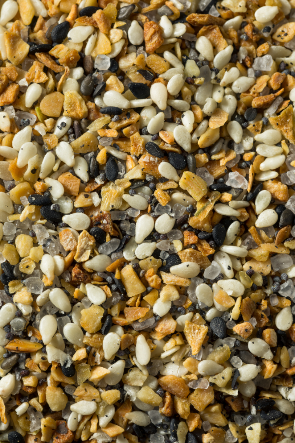 overhead close up shot of everything bagel seasoning - a mix of white sesame seeds, black sesame seeds, poppy seeds, dried garlic, dried onion flakes, and salt