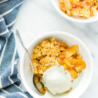 overhead shot of the best apple crisp recipe in small white bowls with a scoop of vanilla ice cream