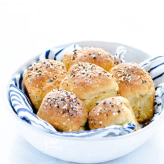 baked Gluten Free Rolls Recipe with Everything Bagel Seasoning in a white bowl lined with a white and navy blue striped cloth napkin