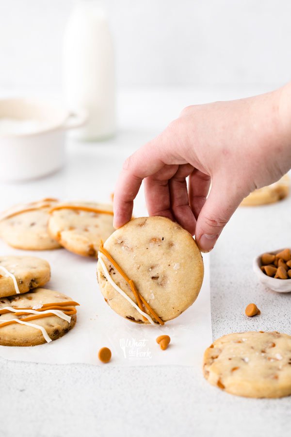 a hand holding up a butterscotch shortbread cookie