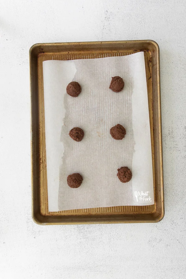 overhead shot of Gluten Free Hershey Kiss Cookie dough balls on a parchment paper lined half sheet pan