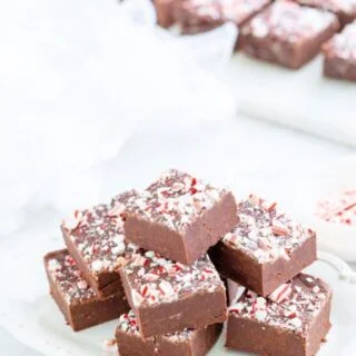 Peppermint Fudge recipe made, sliced, and stacked ready to serve on a small white plate