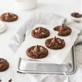 Gluten Free Hershey Kiss Cookies on an upside down quarter sheet pan lined with white parchment paper