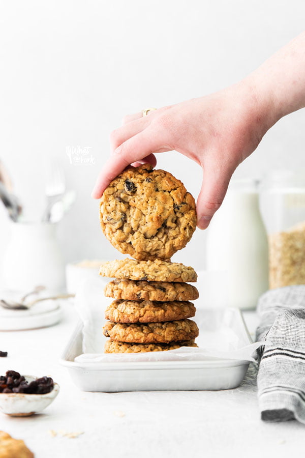 a hand holding a gluten free oatmeal raisin cookie showing the top
