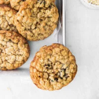 overhead shot of baked gluten free oatmeal raisin cookies on a silver metal sheet pan