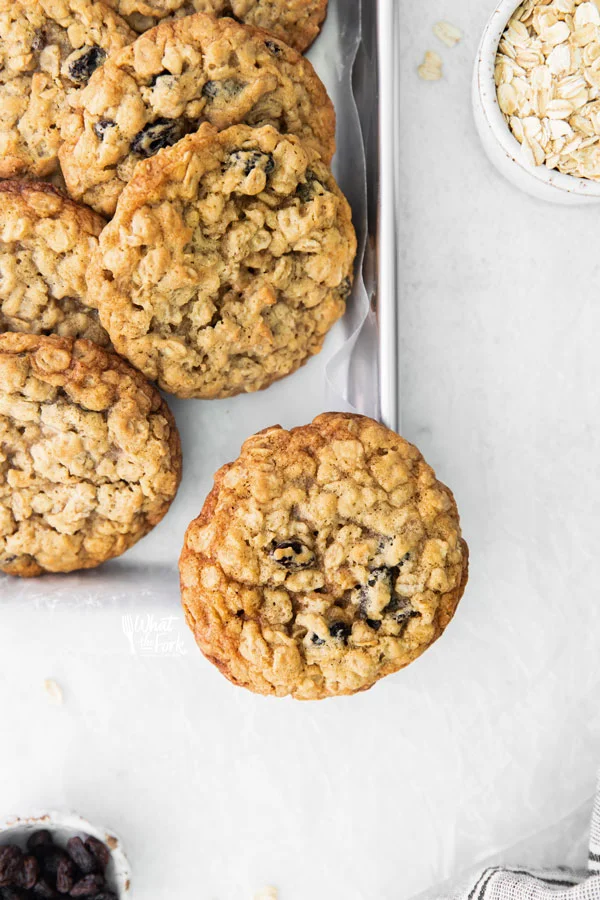 overhead shot of baked gluten free oatmeal raisin cookies on a silver metal sheet pan