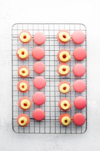 Strawberry Lemon Macarons on a wire rack filled and ready to be topped