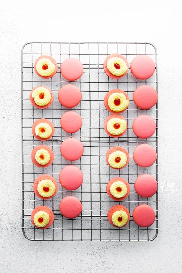 Strawberry Lemon Macarons on a wire rack filled and ready to be topped