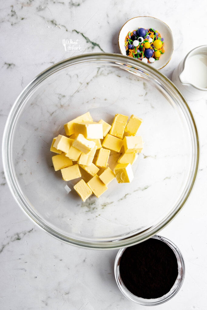 cubed butter in a large glass bowl ready to make black frosting
