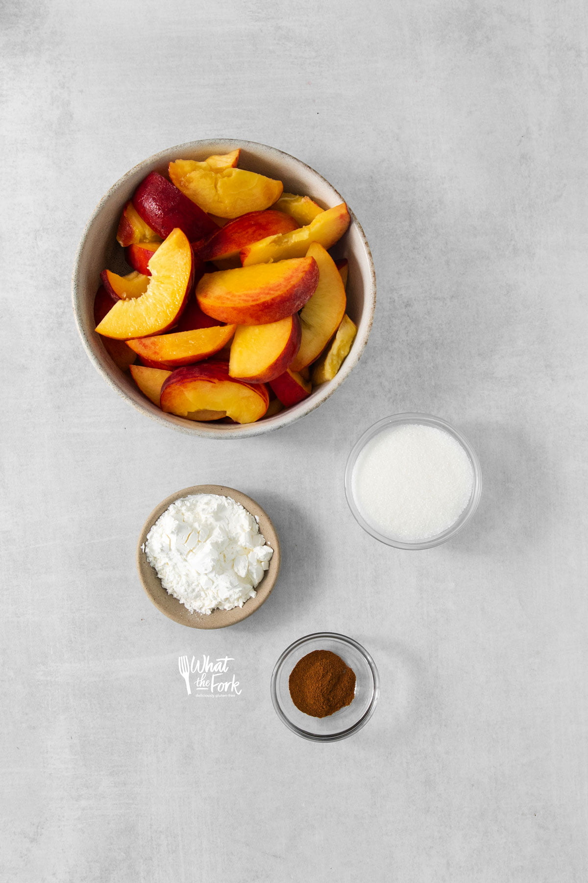 ingredients in individual bowls to make a gluten free peach cobbler recipe