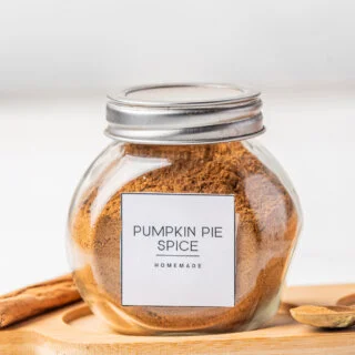 homemade pumpkin pie spice made and stored in a small glass jar with a metal twist top.