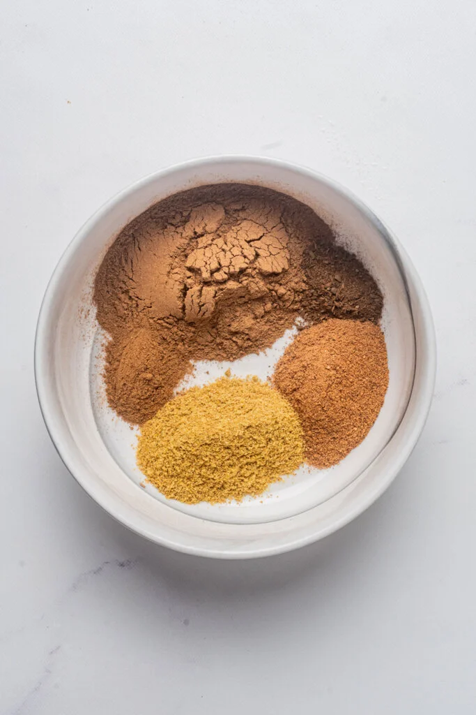 ingredients in a small white bowl to make homemade pumpkin pie spice