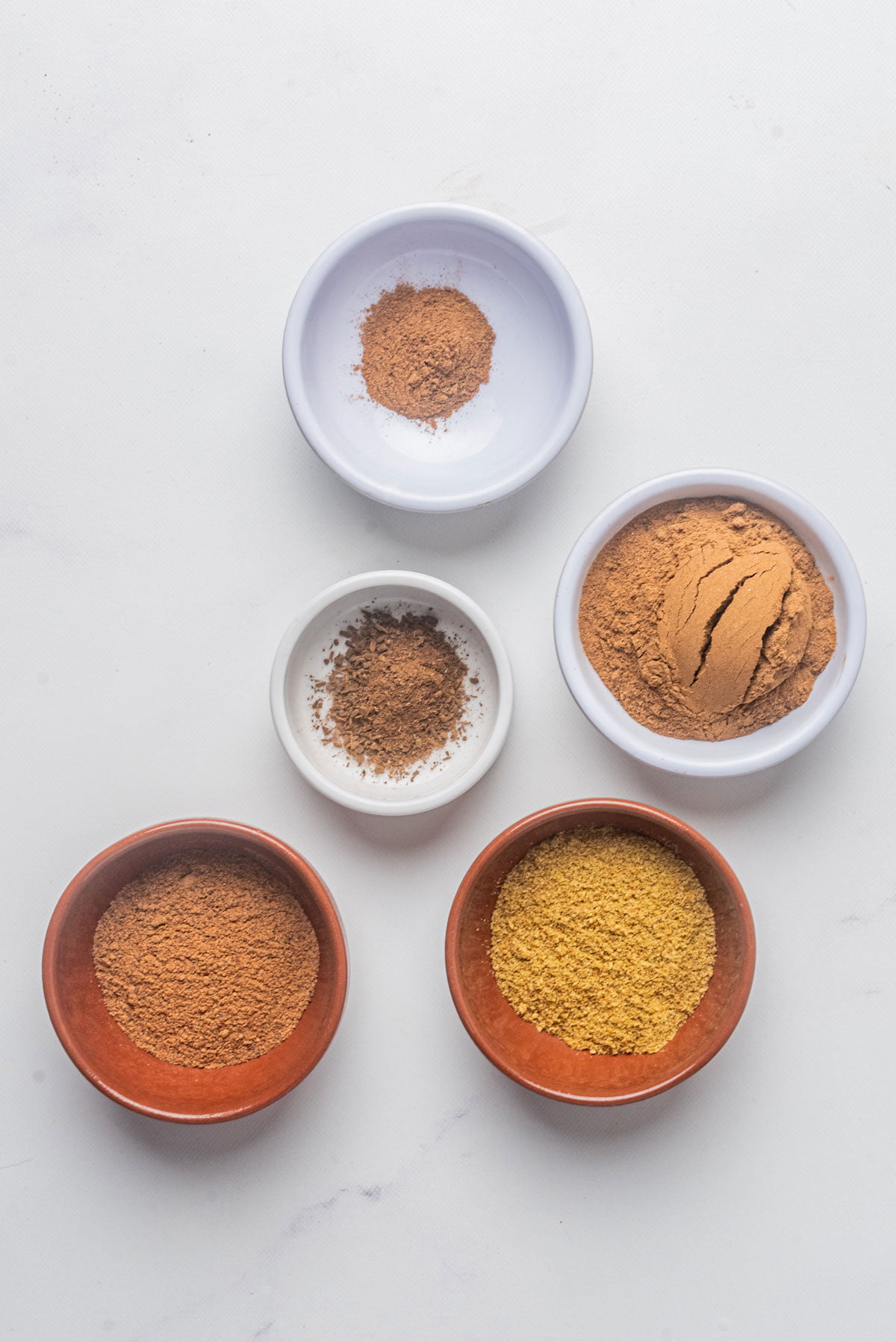 ingredients to make homemade pumpkin pie spice in small individual bowls.