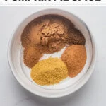 ingredients for Homemade Pumpkin Pie Spice (Easy DIY Recipe) in a white bowl with text for Pinterest