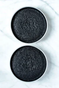 baked gluten free black velvet cake in 2 round metal cake pans